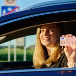Happy Woman Holding Driver License in Car